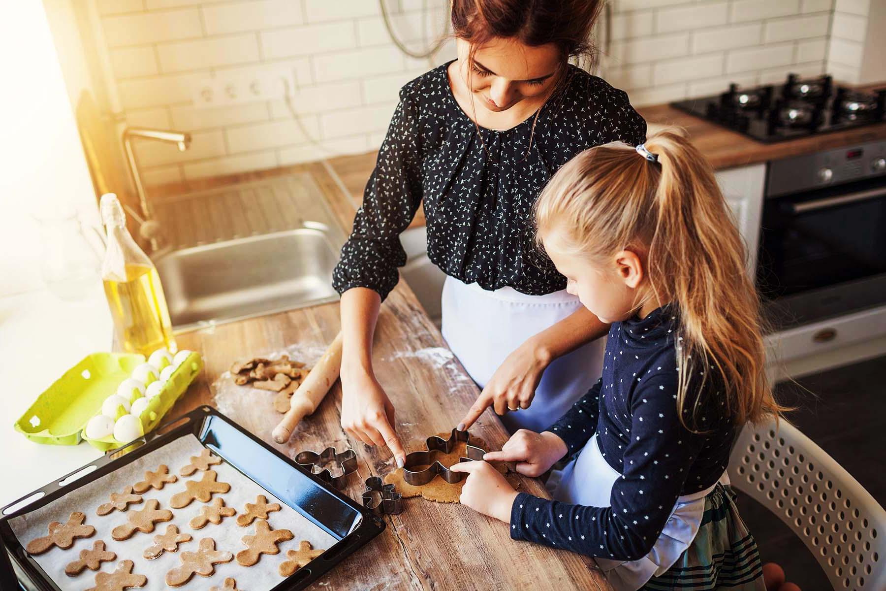 A woman showing a child to bake